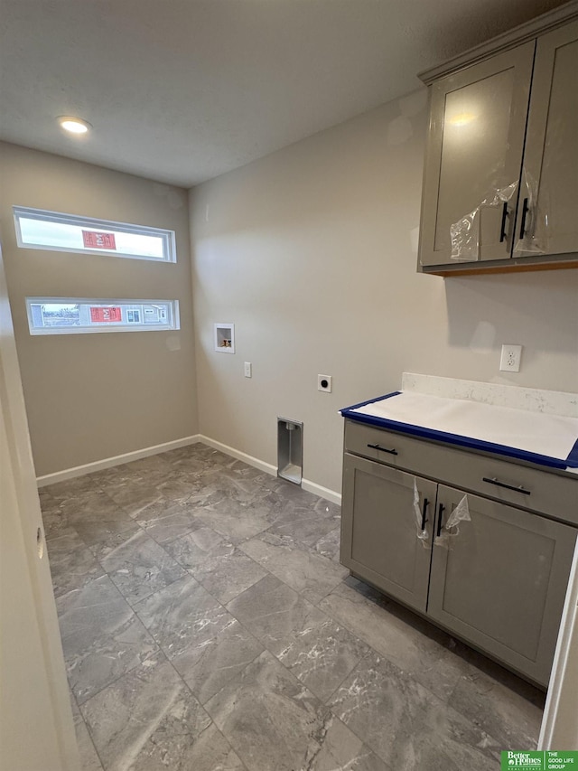 washroom with cabinets, hookup for a washing machine, and hookup for an electric dryer