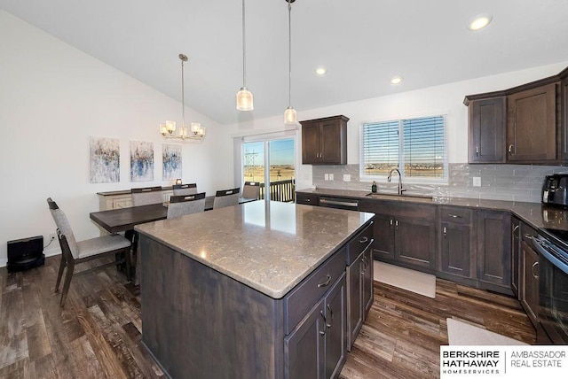 kitchen with tasteful backsplash, sink, a kitchen island, and pendant lighting