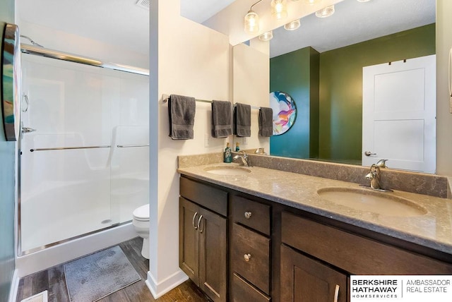 bathroom with vanity, toilet, wood-type flooring, and walk in shower