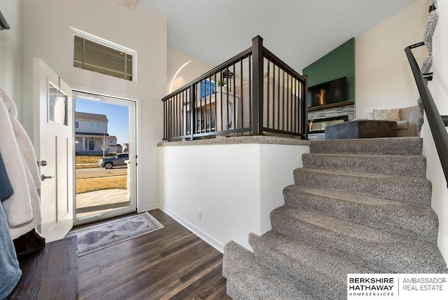 foyer entrance featuring hardwood / wood-style floors and a stone fireplace