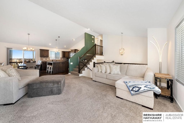 living room featuring light carpet, sink, lofted ceiling, and an inviting chandelier