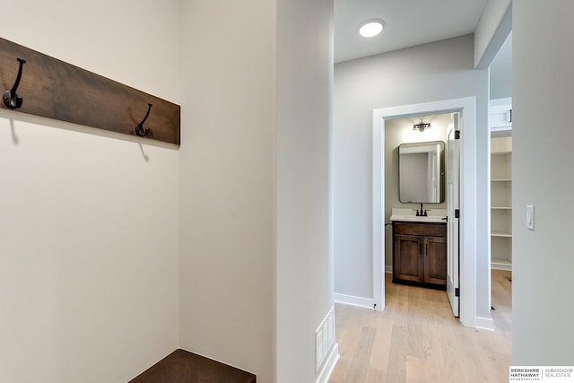 hall featuring light hardwood / wood-style flooring and sink