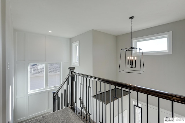 hallway featuring carpet and an inviting chandelier