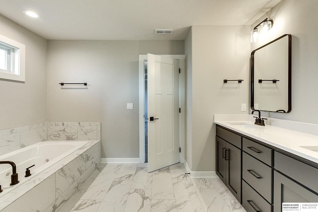 bathroom with tiled bath and vanity