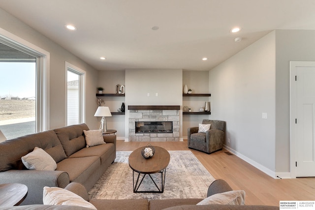 living room featuring light wood-type flooring and a fireplace