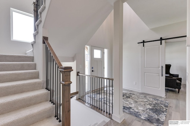 staircase with a barn door and hardwood / wood-style flooring