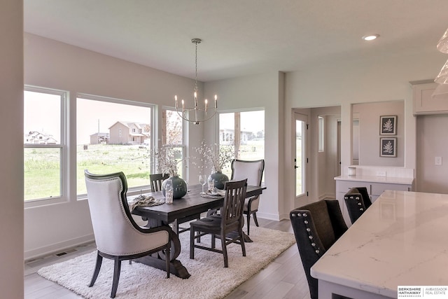 dining room with a chandelier, light hardwood / wood-style floors, and a wealth of natural light