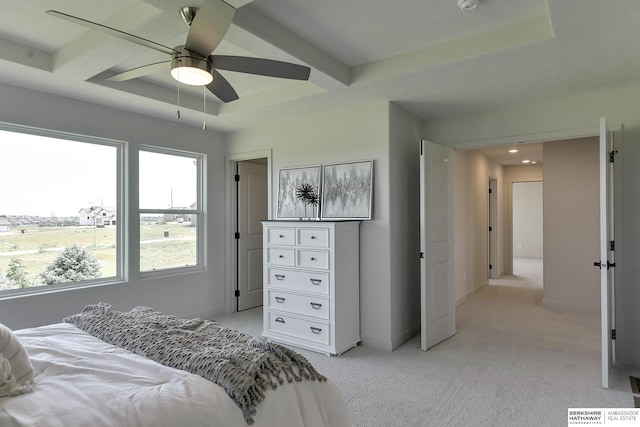 bedroom with light colored carpet, ceiling fan, and a tray ceiling