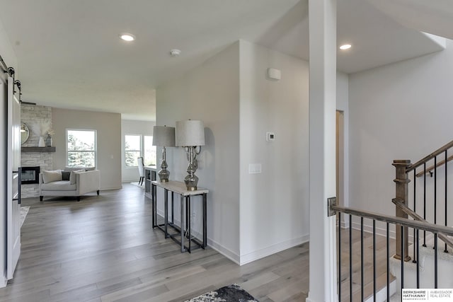 corridor with a barn door and hardwood / wood-style floors