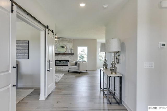 hall featuring a barn door and hardwood / wood-style flooring