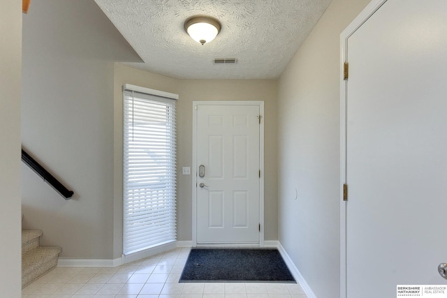 tiled foyer featuring a textured ceiling