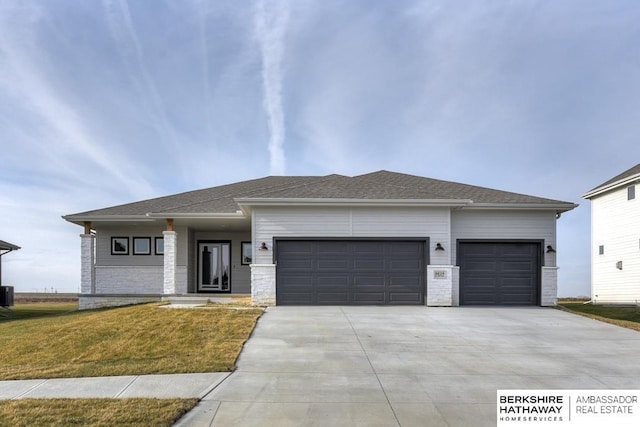 view of front of home featuring central AC unit, a garage, and a front lawn