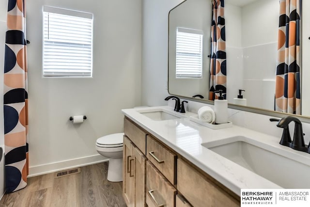 bathroom with plenty of natural light, wood-type flooring, and toilet