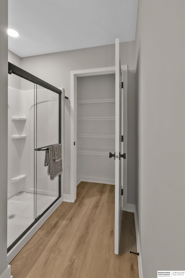 bathroom featuring hardwood / wood-style floors and an enclosed shower