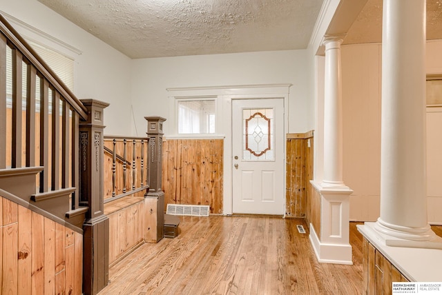 foyer entrance featuring light hardwood / wood-style flooring and a textured ceiling