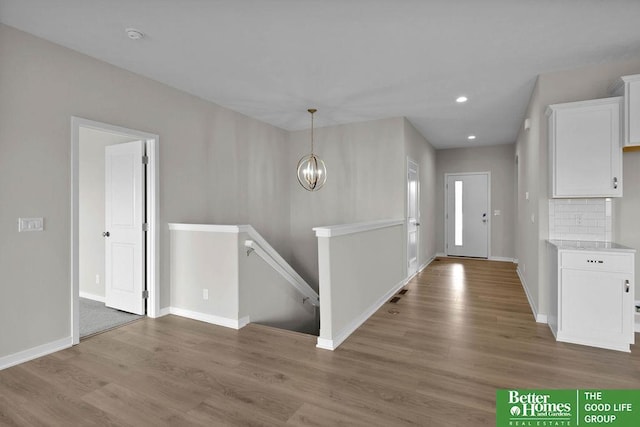 entrance foyer with wood-type flooring and an inviting chandelier