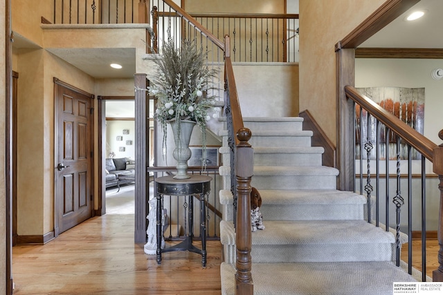 stairway featuring hardwood / wood-style floors and ornamental molding