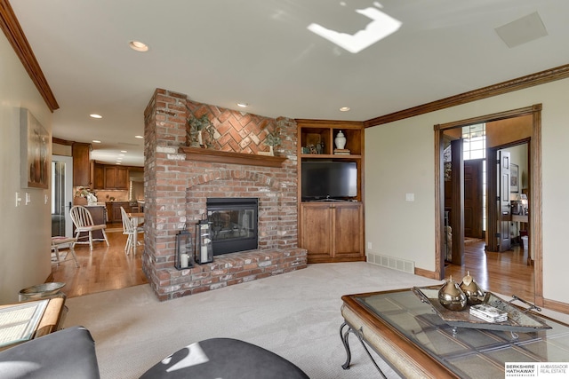 carpeted living room with built in features, ornamental molding, and a fireplace