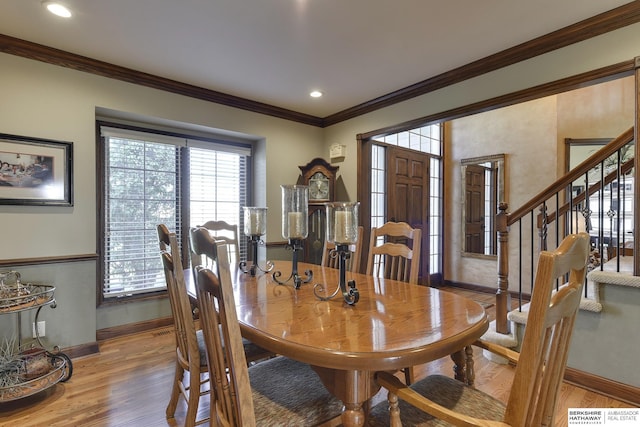 dining room with ornamental molding and light hardwood / wood-style flooring