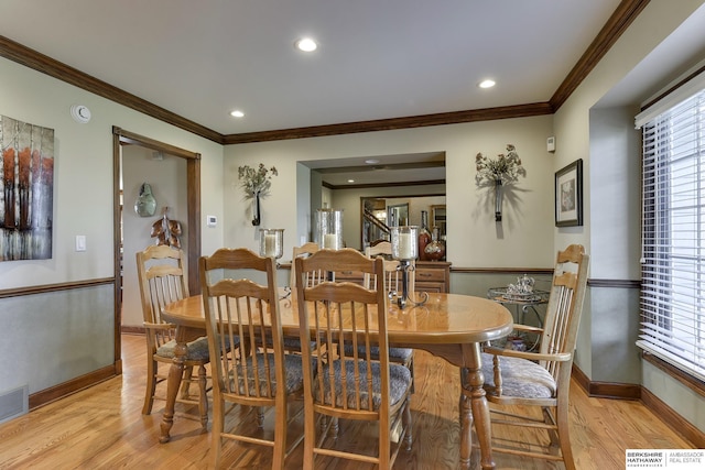 dining space featuring light hardwood / wood-style flooring and ornamental molding