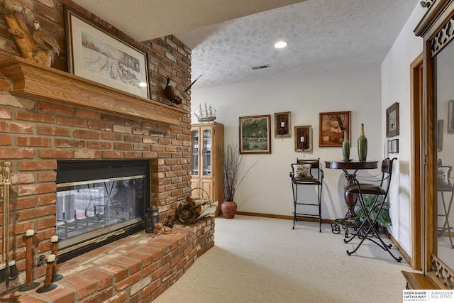 carpeted living room with a fireplace and a textured ceiling