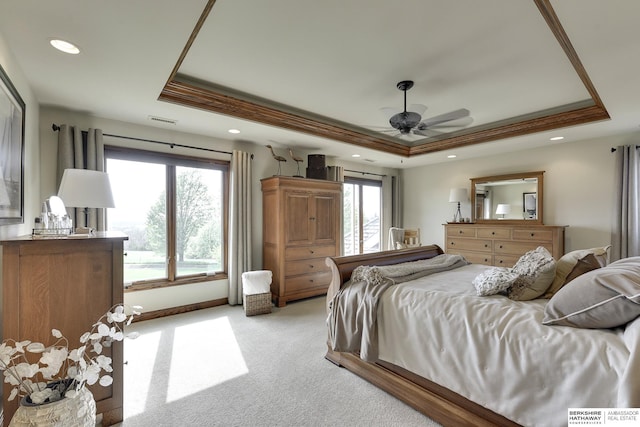 bedroom with light carpet, a raised ceiling, and ceiling fan