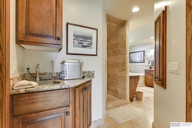 interior space with light stone countertops, light tile patterned floors, and sink