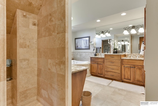 bathroom with a tub to relax in, vanity, and tile walls