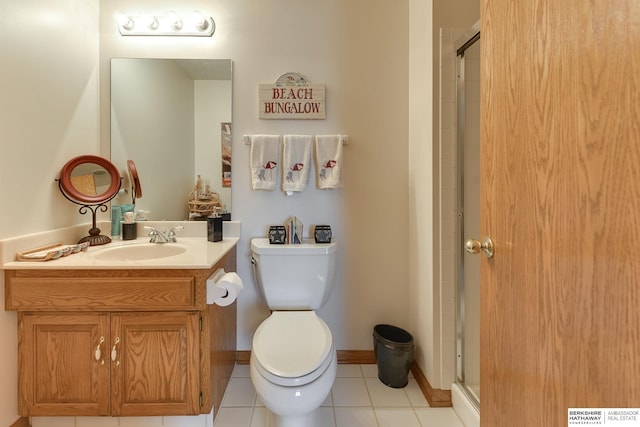 bathroom with tile patterned floors, a shower with door, vanity, and toilet