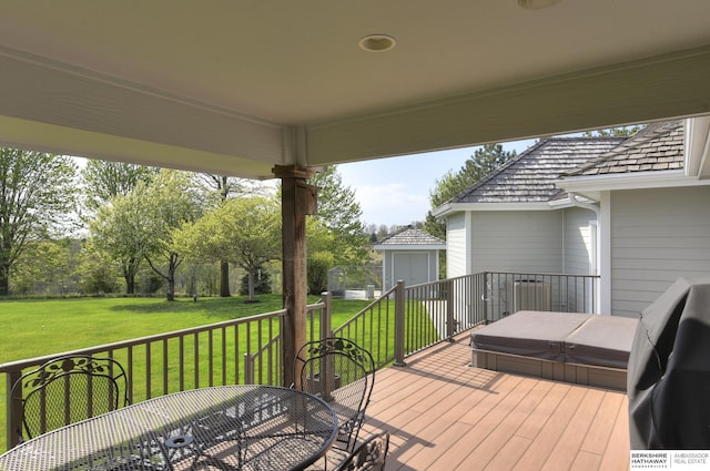 deck featuring a yard, a grill, and a covered hot tub