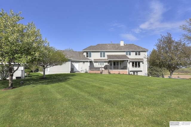 back of property featuring a yard and a deck