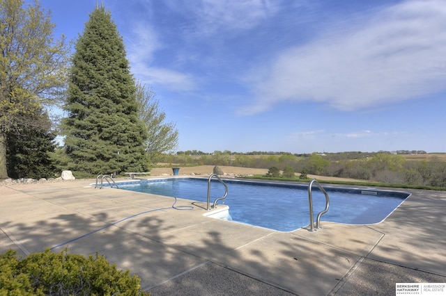 view of swimming pool with pool water feature and a patio area