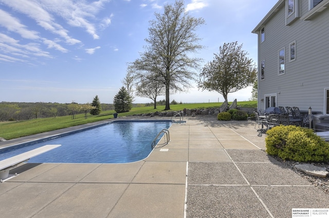 view of pool with a patio, a diving board, and a lawn