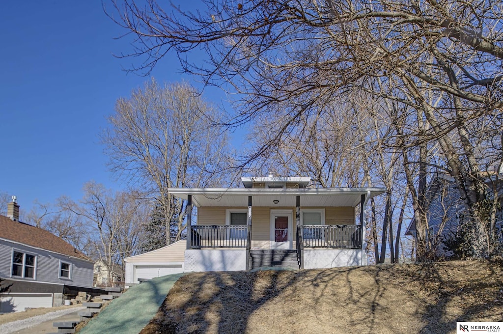 bungalow-style house featuring an outbuilding, covered porch, and a garage