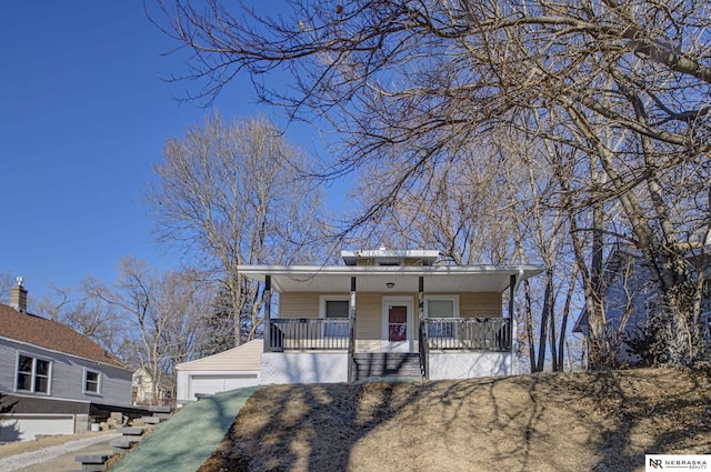 bungalow-style house featuring an outbuilding, covered porch, and a garage