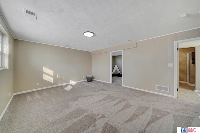 carpeted spare room with a textured ceiling