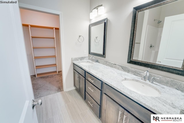 bathroom featuring a shower and vanity