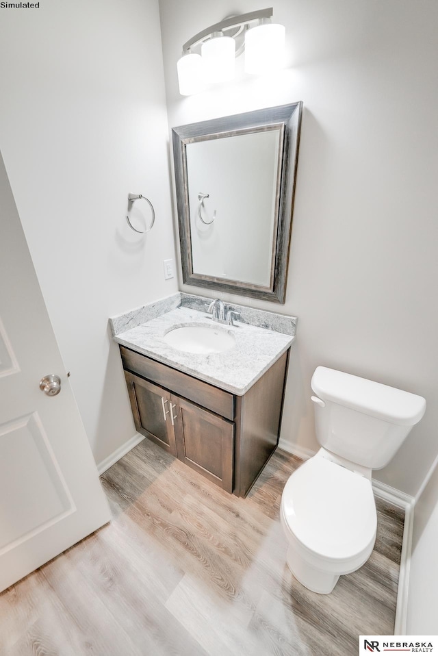 bathroom with hardwood / wood-style flooring, vanity, and toilet