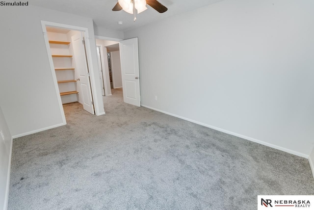 unfurnished bedroom featuring a closet, a spacious closet, ceiling fan, and light colored carpet