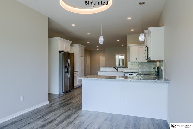 kitchen featuring kitchen peninsula, white cabinets, pendant lighting, and appliances with stainless steel finishes