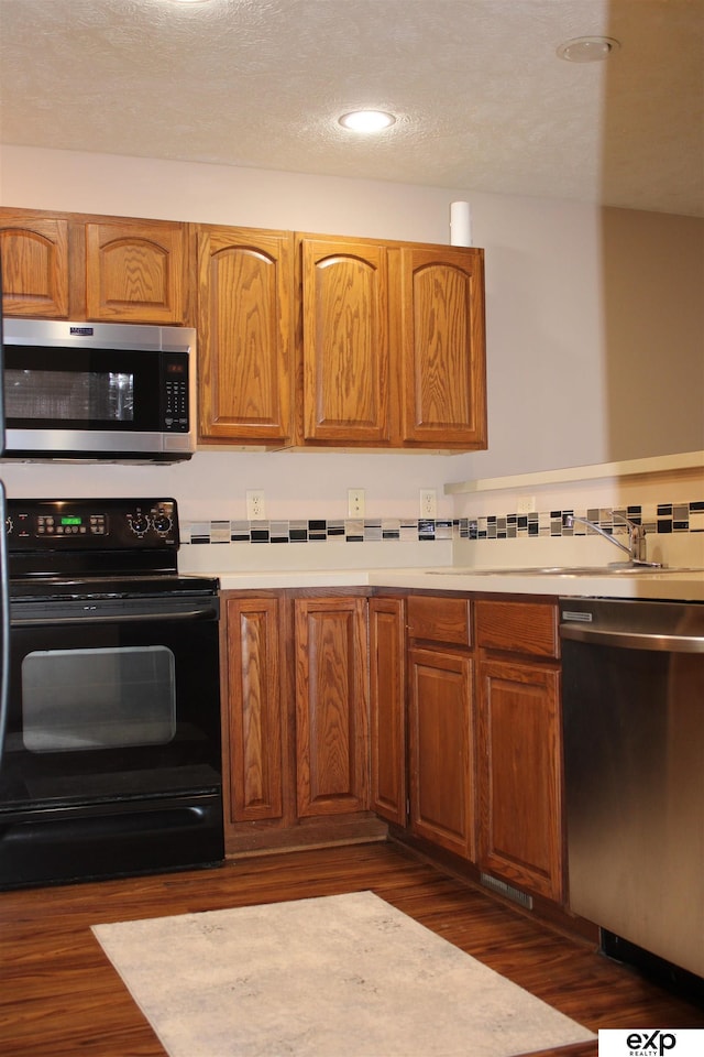 kitchen featuring appliances with stainless steel finishes and dark hardwood / wood-style flooring