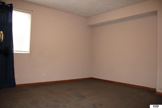 carpeted spare room with a textured ceiling