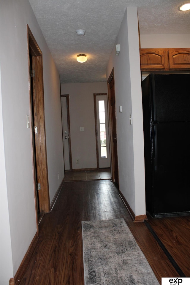 hall featuring dark wood-type flooring and a textured ceiling