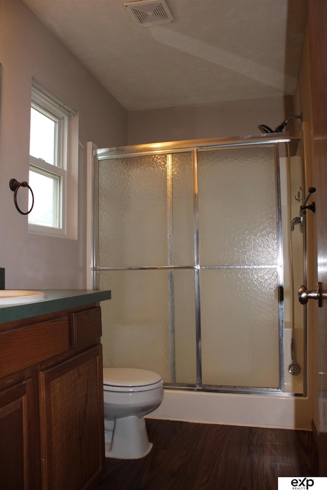 bathroom with vanity, wood-type flooring, an enclosed shower, and toilet