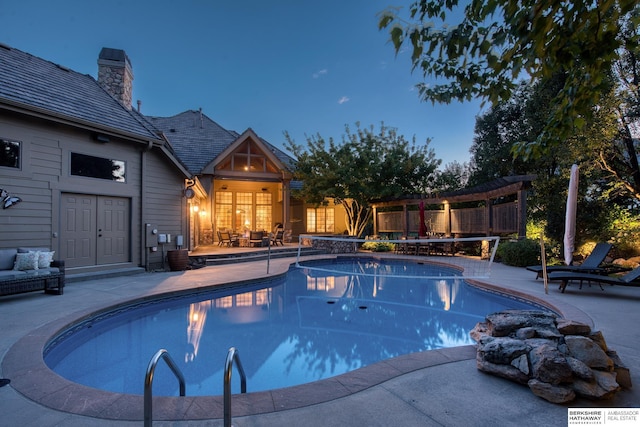 pool at dusk featuring a patio