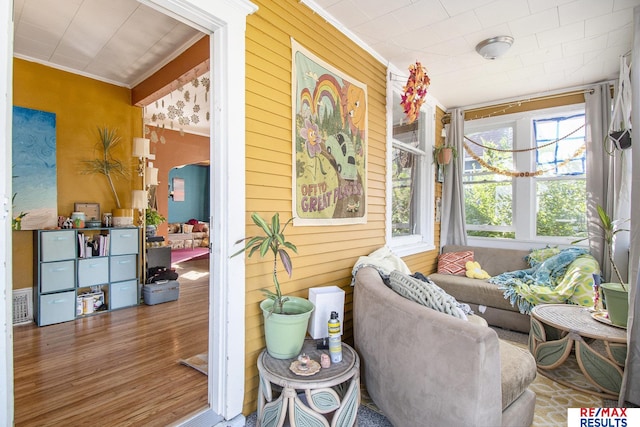 interior space with ornamental molding and wooden walls