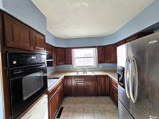 kitchen with stainless steel refrigerator with ice dispenser, sink, light tile patterned flooring, and black oven