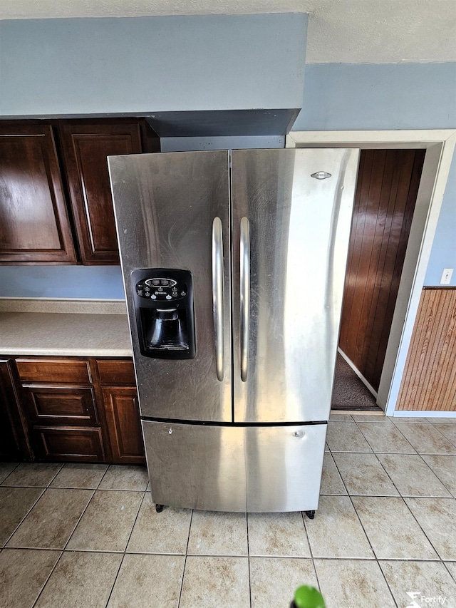 kitchen featuring light tile patterned flooring, stainless steel fridge, and dark brown cabinetry