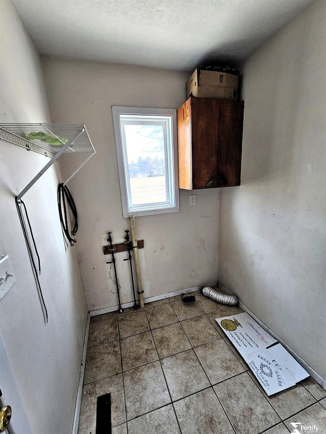 laundry room with light tile patterned floors and cabinets