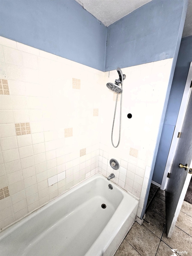 bathroom with tiled shower / bath, tile patterned flooring, and a textured ceiling